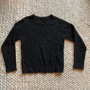 Svart stickad tröja från Vero Moda - Mysig svart stickad tröja från Vero Moda. Perfekt för kyliga dagar med sin klassiska design och långa ärmar. Tröjan har en enkel och stilren look som passar till det mesta. Ett måste i garderoben för den som älskar komfort och stil.