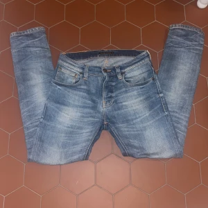 Blå jeansbyxor från Nudie Jeans - Snygga blå jeansbyxor från Nudie Jeans. Storlek: W 28. L 30.  Använda ungefär 4-7 gånger inga defekter. Nypris 1400kr
