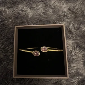 Guldarmband med lila stenar från e&e Lisbon💜 - Guldarmband från e&e Lisaboon  med två lila stenar. Köpt i Lisbon nypris 40 Euro💜Justerbar. Pris kan diskuteras 