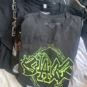 Svart och vit t-shirt med tryck - Säljer en cool svart t-shirt från Bladee med neonfärgat tryck och en vit t-shirt med ett unikt svart tryck. Perfekt för dig som gillar streetwear och vill sticka ut med grafiska mönster.