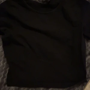 Svart kortärmad topp - Säljer en stilren svart kortärmad topp i mjukt material. 