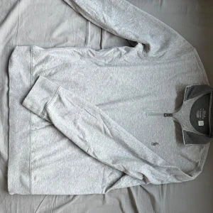 Ralph lauren tröja - Säljer en stilren grå tröja från Polo Ralph Lauren med halv dragkedja och broderad logga på bröstet. Perfekt för en avslappnad look. Tröjan har långa ärmar och är tillverkad i mjukt material för extra komfort. 