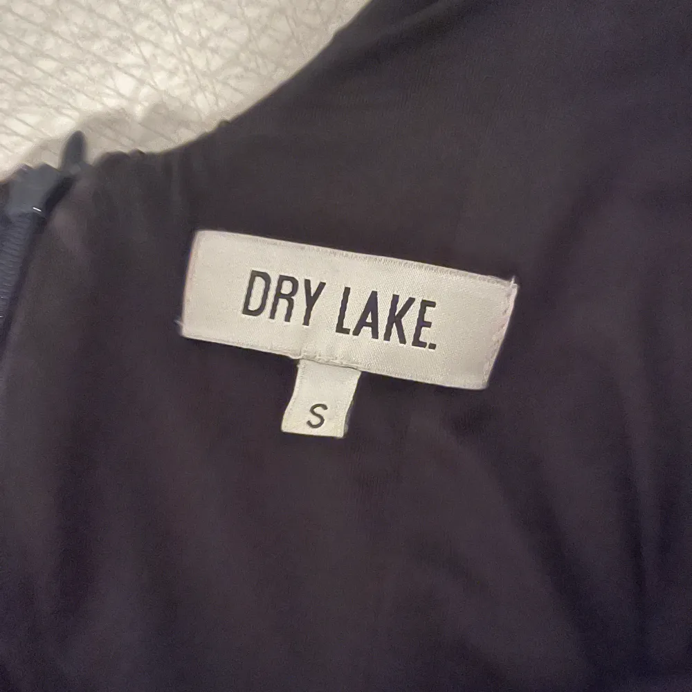 Säljer en superfin svart glittrig klänning från Dry Lake i storlek S. Perfekt för festliga tillfällen med sitt snygga mönster och glittriga detaljer. Klänningen har en tight passform och ärmlös design som ger en elegant look. Den är i använd skick men sparsam och redo för nästa party!. Mekot.