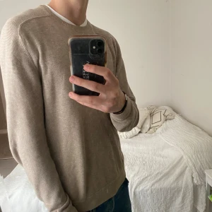 Beige tröja från Kappahl - Säljer en stilren beige tröja från Kappahl i storlek S. Den är perfekt för både höst och vår med sin mjuka bomullskänsla. Tröjan har långa ärmar och en klassisk rund halsringning. Passar perfekt till jeans för en avslappnad look. 🧥den har ett litet hål vid ena sömmen på ärmen