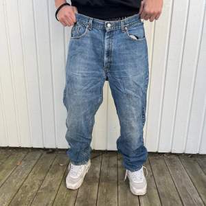 Säljer ett par klassiska blå Levi's jeans i baggy stil. De är i välanvänt skick men fortfarande snygga och bekväma. Perfekta för en avslappnad look. Passar bra till sneakers och en t-shirt. Perfekt för höst och vår!