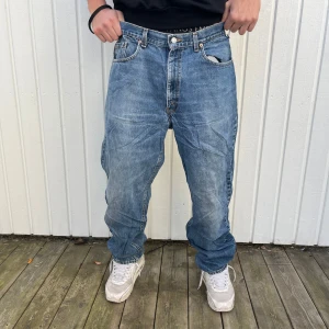 Blå jeans från Levi's - Säljer ett par klassiska blå Levi's jeans i baggy stil. De är i välanvänt skick men fortfarande snygga och bekväma. Perfekta för en avslappnad look. Passar bra till sneakers och en t-shirt. Perfekt för höst och vår!