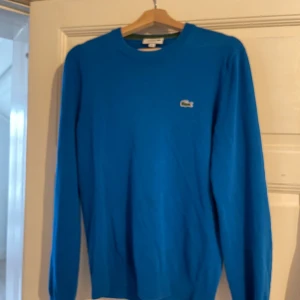 Lacoste tröja  - Säljer min Lacoste tröja då jag vuxit ur den, den är i väldigt fint skick. Snyggt och skönt material, bra passform. Skriv för frågor. Nypris ca 1200kr