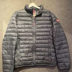 Colmar dunjacka - Säljer en snygg blågrå pufferjacka från Colmar i storlek L men skulle säga att den passar mer som en M. Jackan är perfekt för höst och vinter. Har en inne ficka. Mycket bra skick. 