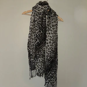 Sjal i leo-print - Härlig, stor sjal i leopard-print. Fransar på kortändorna.