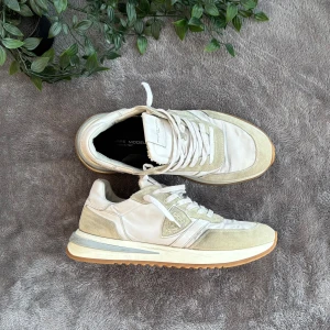 Vita sneakers från Philippe Model TRPZ - Philippe Model TRPZ Storlek 41. Skorna är i mycket bra skick och har en fantastisk design och stilren logga. Ingen box medföljer.   Storlek: 41 EU  Skickas med PostNord 📦  Vid funderingar är det bara att fråga på.   Onlinekvitto kan medfölja vid behov.