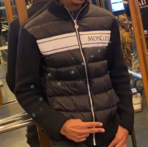 Moncler Cardigan  - Snygg svart pufferjacka från Moncler med vit logotyp på bröstet. Jackan har en dragkedja framtill och långa ärmar i stickat material. Perfekt för kyligare dagar med sin quiltade design. Har haft den i nån månad och vill lja den. Hör gärna av er ☺️          