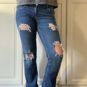 Blå jeans med slitningar - Snygga blå jeans från Zara med coola slitningar på låren och knäna. Slitningarna är gjorda själv. Perfekta för en avslappnad stil. Se defekt på sista bilden!
