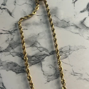 Guldhalsband  - GRINDA MALOU NECKLACE GOLD Grinda  Klassiskt halsband med modern twist. Passar till vardags och till festen. Tillverkade av rostfritt stål, guldplätterad. Fri från nickel. Längd: 42 cm. Färg: Guld  Mått 42x0.5x0.5 cm Pris 400 kr och med fri frakt 