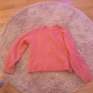 Rosa stickad tröja - Säljer en mysig rosa stickad tröja med rund hals och långa ärmar. Perfekt för kyliga dagar och ger en härlig färgklick till garderoben. Tröjan har en mjuk och fluffig textur. Och är använd väl så är ganska nopprig som man ser på bild 4💞