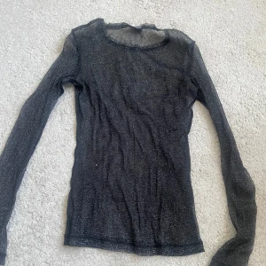 Svart glittrig topp från Gina Tricot - Säljer en svart glittrig topp från Gina Tricot i storlek XS. Perfekt för fest och nyår. Köpt på Vinted och har endast använt den en gång.🎉