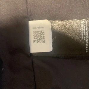 Svart väst från The North Face - Säljer en svart väst från The North Face med dragkedja framtill. Västen är en del av Mix-N-Match-serien och kan kombineras med andra lager. Perfekt för att hålla värmen utan att bli för varm.