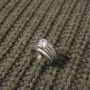 Vine Whisper - Silver Ring with Stone - US storlek 7, diameter 17,3 mm, omkrets 54,4 mm. Inspirerad av naturens slingrande rankor. Den gnistrande stenen i mitten reflekterar ljus från alla vinklar, och designen är delvis justerbar för en bekväm passform.