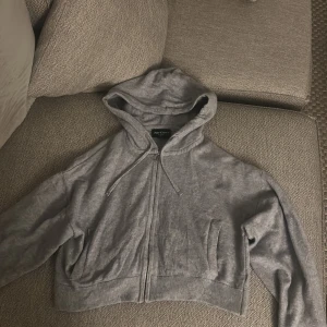 Grå hoodie från Juicy Couture - Säljer en snygg grå mag hoodie från Juicy Couture. Den har dragkedja framtill och en praktisk huva med snören. Perfekt för en avslappnad stil. 💫