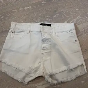 Säljer ett par snygga vita jeansshorts från Replay. De har en fräsch fransig kant och knappar framtill. Perfekta för sommaren och passar till nästan allt! 