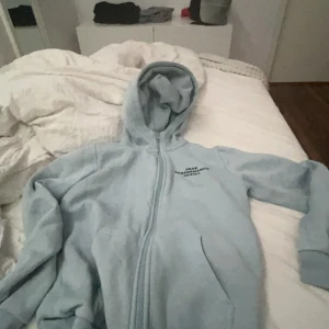 Ljusblå hoodie från Peak Performance - Säljer en supermjuk och bekväm ljusblå hoodie från Peak Performance. Den har en dragkedja framtill och en skön huva. Perfekt för kyliga dagar eller mysiga hemmakvällar. Den är i bra skick och redo för en ny ägare! Storlek 150.