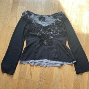 Svart långärmad topp  - Svart långärmad topp med vackra rosdetaljer. 