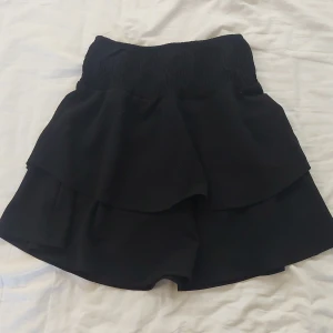 Svart kortkjol från ONLY - Säljer en jättefin svart kortkjol då den är för stor för mig. Den är från ONLY i storlek 34 (XS). Kjolen har en elastisk midja och volangdetaljer.🖤 Nästan helt oanvänd