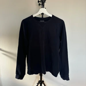 Svart långärmad tröja  - Säljer en stilren och enkel marinblå sweatshirt. Perfekt för både vardag och fest. Tröjan är i bra skick och har en normal passform. Passar till allt och är ett måste i garderoben!