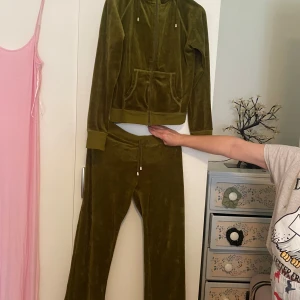 Olivgrön velour hoodie från L&B - Säljer en supermjuk och bekväm olivgrön velour hoodie från L&B (lingon och blåbär) Perfekt för mysiga dagar hemma eller en avslappnad dag ute. Den har långa ärmar och en klassisk hoodie-stil med dragsko i huvan. Matcha med de tillhörande byxorna för en komplett look!