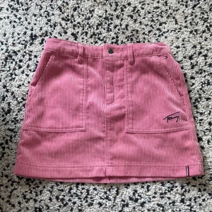 Low waist rosa jeans kjol - Rosa jeans kjol från Tommy hifiger. Står storlek 152 men passar xxxs/xxs om man vill att den ska sitta lowaist och lite kortare! Det går att justera midjemåtten, men den är 33 cm tvärs över för mig. Kjolen är 35 cm lång. 