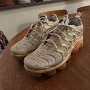 Nike Air Vapormax Plus - Vita och orangea  Nike Air Vapormax Plus i bra skick, endast lite smutsiga men de går att tvätta av. De vita har INTE  blivit missfärgat 