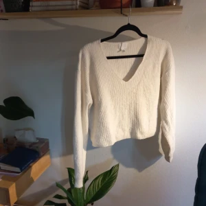 Vit stickad tröja från H&M - Säljer en mysig vit stickad tröja från H&M med v-ringning. Tröjan har långa ärmar och en bekväm passform, perfekt för kyligare dagar. Ett stilrent plagg som passar till det mesta. 🌟