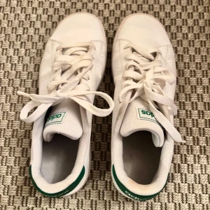 Adidas advantage  - Vit klassisk adidas sneaker med gröna detaljer, storlek 36 2/3. Jag är normalt en 37 och passar mig fint. Knappt använda. Gott skick.
