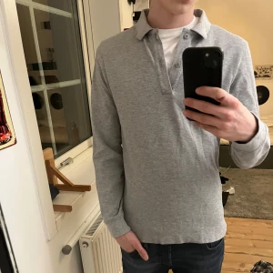 Grå pikétröja - Säljer en stilren grå pikétröja med långa ärmar. Perfekt för en avslappnad men ändå snygg look. Tröjan är från donce de la sense. Använd typ 2 gånger och är i storlek 170/xs. Perfekt till sena sommarkvällar 