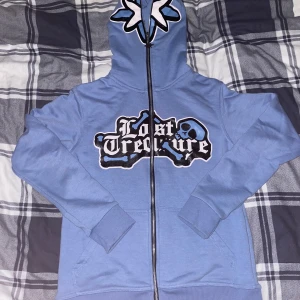 Blå kofta - Tvär fet kofta med trycket ”lost treasure” 10/10 skick. Trycket går inte bort i tvätten. Storlek XS/S Pris går att diskuteras