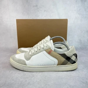 Burberry skor  - Snygga sneakers med en kombination av vitt och rutigt mönster. Skorna har snörning och detaljer i mocka som ger en stilren look. Perfekta för en avslappnad stil. Av märket burberry