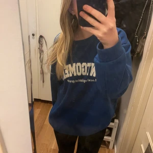 Blå sweatshirt - Säljer en blå sweatshirt från Shein med tryck framtill. Tröjan har en avslappnad passform och långa ärmar, perfekt för en casual look. Den är gjord i ett mjukt material som känns skönt mot huden. Perfekt för kyligare dagar!