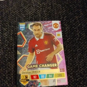 Panini FIFA 365 Adrenalyn XL Game Changer-kort - Samlarobjekt från Panini FIFA 365 Adrenalyn XL-serien. Kortet visar Christian Eriksen med  'Game Changer' edition.Perfekt för fotbollsfans och samlare av sportkort.