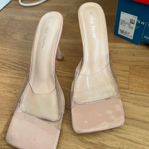 Transparenta klackskor från Public Desire - Snygga klackskor med transparenta remmar och en fyrkantig tå från Public Desire. Skorna har en ljusrosa sula och en elegant design som passar perfekt för en trendig look.