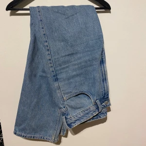 Blå jeans från Weekday - Säljer ett par blå jeans från Weekday i modellen 'Rowe extra high straight'. De har en klassisk blå färg och rak passform som ger en tidlös look. Perfekta för dig som gillar högmidjade jeans med en avslappnad stil. Superskick bortsett från små fläckar, bild 4.