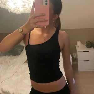 Svart one sholder topp/ tub topp - Väldigt fin och sitter tight. Går att ha både som på första bilden eller som tub topp genom att vara vika ned axel bandet. Pris kan diskuteras!