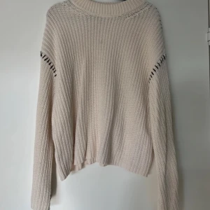 Beige stickad tröja med detaljer - Mysig beige/vit stickad tröja med långa ärmar och dekorativa svarta detaljer vid ärmarna. Perfekt för kyliga dagar och ger en avslappnad stil. Passar bra till jeans eller kjol för en trendig look. Från Gina Tricot och är helt slutsåld!❤️