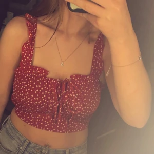 Rött linne - Söt röd topp med vita hjärtan och knytning framtill. Den har volangdetaljer på axelbanden och är croppad. Perfekt för en somrig look!❤️🤍Säljer den då den är för liten för mig, aldrig använt✨Hör av dig ifall du är intresserad✨