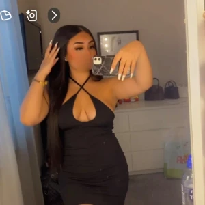 Svart klänning med halterneck - Snygg svart klänning med halterneck-design och djup urringning. Perfekt för en utekväll eller fest. Klänningen är tight och kort, vilket ger en stilren och elegant look.🤗Använd en gång 