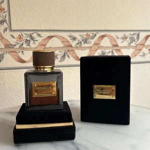 Dolce & Gabbana Eau de Parfum - Säljer en lyxig Dolce & Gabbana Eau de Parfum i en elegant mörk glasflaska med guldiga detaljer. Flaskan rymmer 150 ml, se på bild hur mycket som är kvar.  Kommer i en stilren svart sammetsbox med guldfärgad etikett. 