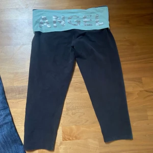 Svarta leggings från Victoria's Secret - Säljer ett par svarta leggings från Victoria's Secret. De har en bred, turkos midja med texten 'ANGEL' i glittriga bokstäver. Jätte söta. Materialet är mjukt och stretchigt för bästa komfort.