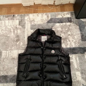 Moncler tibb down väst  - Hej säljer denna moncler tibb down västen i storlek 2/S-M vet ej om västen är äkta så därav priset. Priset kan diskuteras vid snabb affär hör av er vid minsta lilla fråga😁👍
