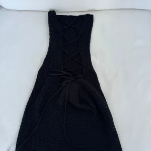 Stickad klänning  - Stickad klänning med knytning i ryggen. Köpt i London, vet inte märket! Aldrig använd så den inte passa mig.