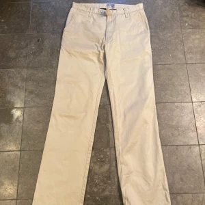 Beige byxor från J.Lindeberg - Säljer ett par stilrena beige byxor från J.Lindeberg. De har en klassisk design med raka ben och en normal passform. De är i bra skick