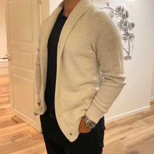 Krämvit cardigan - Skicket är som ny. Krämvit färg som lyser irl. Sitter bra. Passar S/M