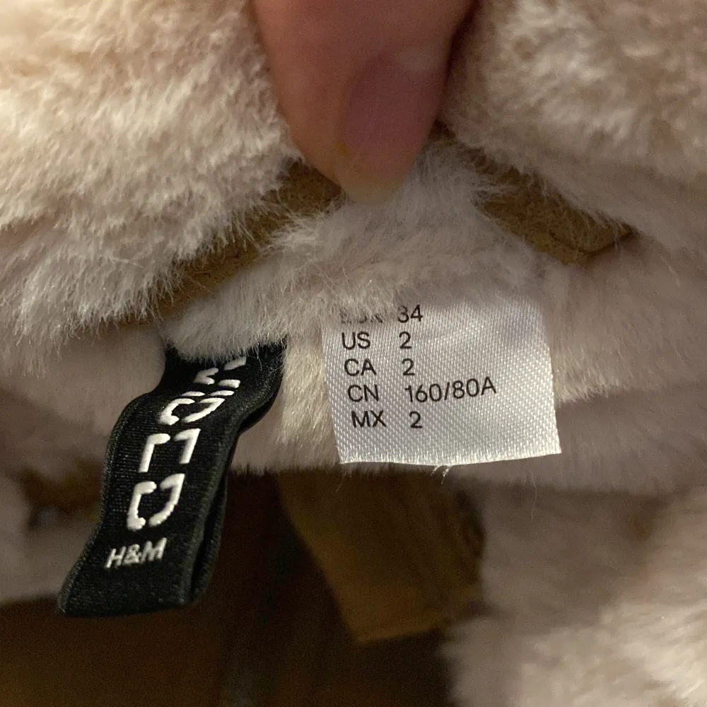 Säljer en superfin brun mockajacka från H&M i storlek 34. Den har ett mysigt vitt foder som syns vid kragen och ärmsluten. Jackan har en dragkedja framtill och snygga spännen vid kragen för extra stil. Perfekt för höst och vinter!. Jackor.